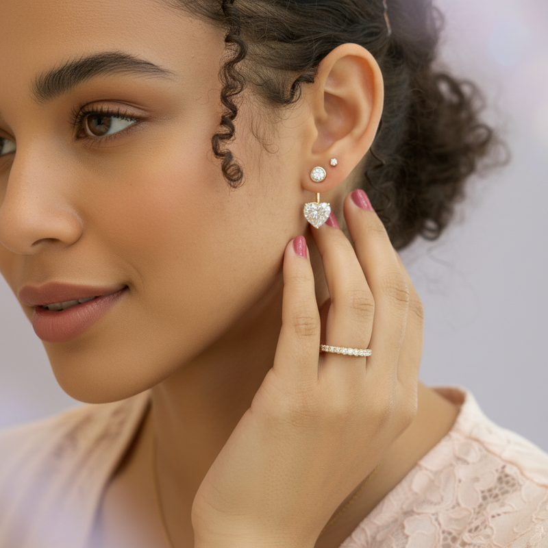 A beautifully lit lifestyle scene featuring a female model wearing the Mariposa Earrings Jackets set against a softly blurred pastel lavender background. The model is in a tasteful, romantic ensemble that complements Valentine’s Day, with her hair styled n