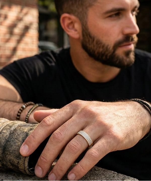 Close-up of Tessera unisex diamond band ring in 10K yellow gold on a male model's hand, showcasing a slim band and modern style from a cool angle.