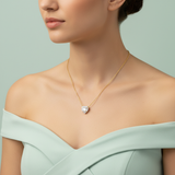 A studio shot with an HDR lighting setup from a Sony A7R IV camera with a 90mm macro lens at f/4 to capture detailed textures of the necklace. The female model stands against a minimalist pastel mint backdrop, dressed in an elegant pastel mint off-shoulder