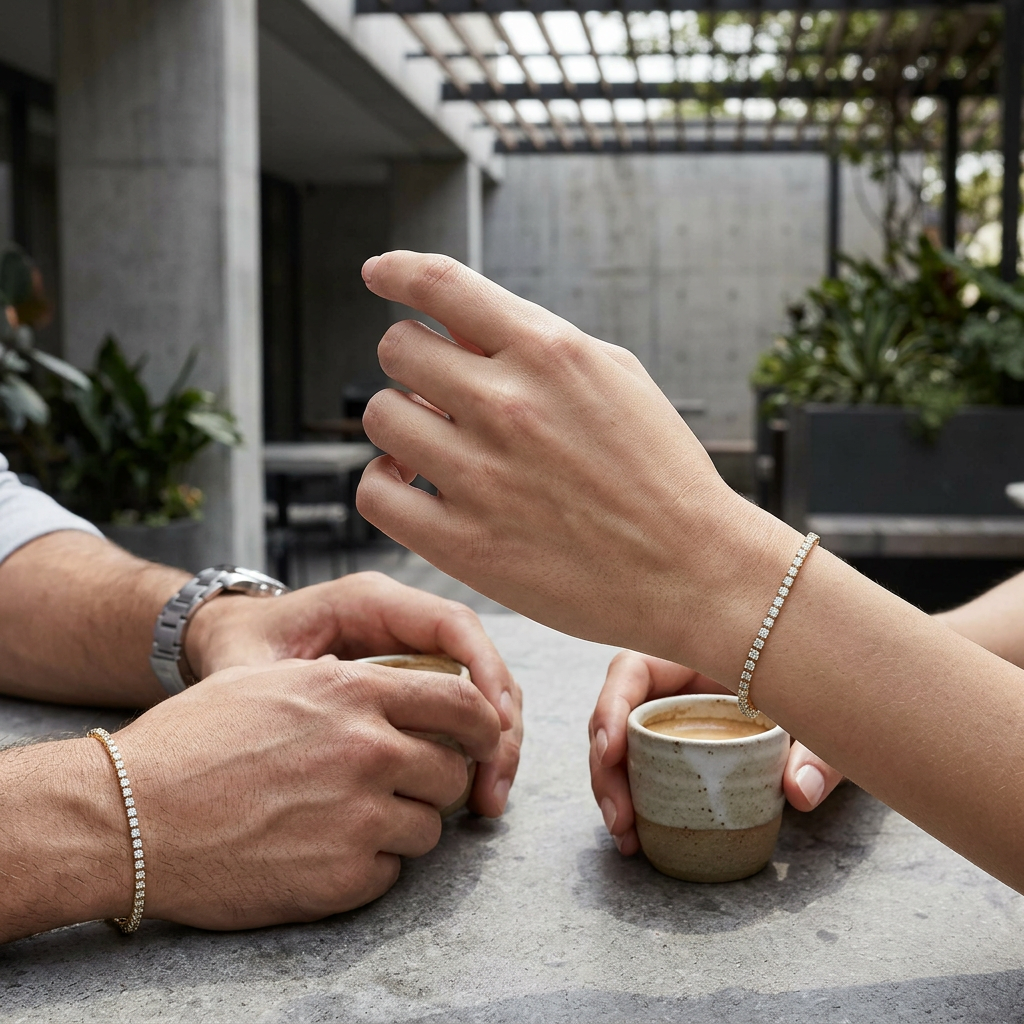 Wide shot of male and female hands with slim yellow gold lab-grown diamond bracelets in a stylish outdoor urban setting, showcasing elegance and modern design.