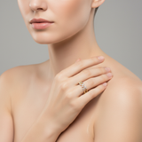 A professional studio shot of a slim female model with fair skin, captured from the waist up, wearing the Amorra 14K Yellow Gold 'LOVE' Diamond Ring on her finger. The lighting is softbox diffused daylight, highlighting the warm glow of the gold and the sp