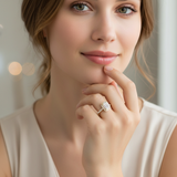 Photorealistic portrait of a female model with face visible, wearing a yellow gold emerald-cut halo engagement ring. Average ring size US 6.5, natural hand proportions. Center emerald-cut diamond appears modest and understated (approx 7.2 × 5.2 mm visual s