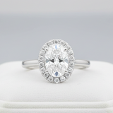 A highly detailed, studio-shot of the Idalia 14K White Gold Oval Lab Grown Diamond Halo Engagement Ring, captured with a macro lens at 100mm focal length. Softbox lighting creates gentle, even illumination highlighting the 1.9 Ct oval lab-grown diamond's b