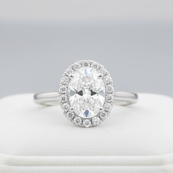 A highly detailed, studio-shot of the Idalia 14K White Gold Oval Lab Grown Diamond Halo Engagement Ring, captured with a macro lens at 100mm focal length. Softbox lighting creates gentle, even illumination highlighting the 1.9 Ct oval lab-grown diamond's b