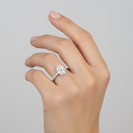 studio softlight model image on female model hand, wearing solce oval ring. The oval diamond is 10mm in length and 6.5mm in width. make the ring smaller than it is