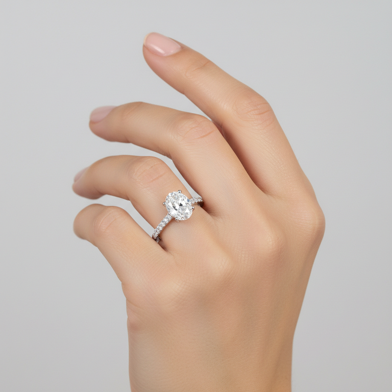 studio softlight model image on female model hand, wearing solce oval ring. The oval diamond is 10mm in length and 6.5mm in width. make the ring smaller than it is