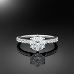 Design a detailed product showcase image of the Freya engagement ring laid flat on a reflective, glass surface with a glossy m backdrop. Use HDR studio lighting with a diffused key light to highlight the intricate prong setting, side diamonds, and the smoo