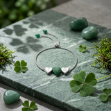 Refined sterling silver bracelet with polished green aventurine heart charm shown on sleek surface, emphasizing its lustrous finish in a modern studio setting.