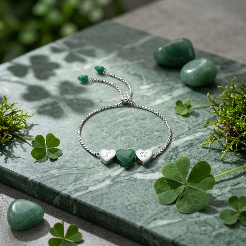 Refined sterling silver bracelet with polished green aventurine heart charm shown on sleek surface, emphasizing its lustrous finish in a modern studio setting.