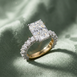Artistic high-resolution image of Maelis engagement ring on textured sage green fabric, showcasing micro-details and radiant cut brilliance.