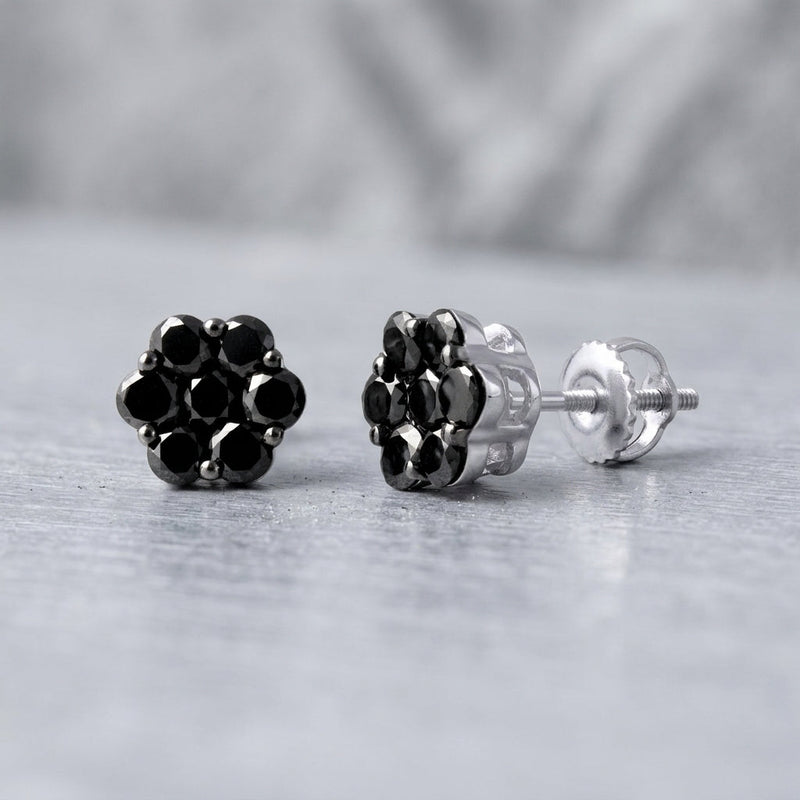 Close-up of 1.1ct black diamond cluster studs in 10K white gold, highlighting their intricate design and sparkling diamonds with soft natural lighting.