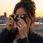 Model lifting camera with visible engagement ring on hand, rooftop sunset scene, playful street style, showcasing the Isidora 14K white gold lab-grown diamond ring.