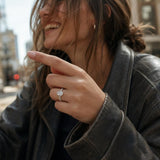 Oval lab grown diamond engagement ring in 14K white gold with side diamonds, natural scene, candid moment