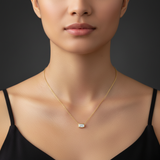 A professional studio shot focused on a human female model’s neck and collarbone, set against a minimalistic, dark-toned backdrop for high contrast. The model faces directly forward, with soft, diffuse lighting from multiple sources to evenly illuminate th