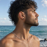 Emerald cut black spinel stud earrings in 925 sterling silver worn by a man in a side profile coastal portrait.