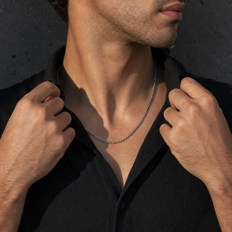 Masato bold rolo chain necklace in 925 sterling silver worn by a model in a black shirt against a dark concrete background.