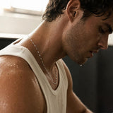Close-up of a 925 sterling silver bar chain necklace resting on the neck of an athletic man.
