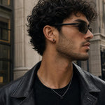 Close-up of a man wearing Kiri princess-cut black spinel stud earrings set in 925 sterling silver.