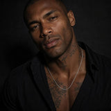 A man wearing a 3.0mm polished 925 sterling silver rope chain necklace, styled with an unbuttoned shirt in a dark editorial portrait.