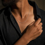 Naoki sterling silver diamond-cut cable chain necklace worn by a man in a black linen shirt.