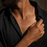 Naoki sterling silver diamond-cut cable chain necklace worn by a man in a black linen shirt.
