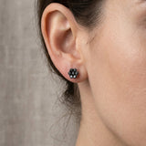 Full view of 1.1ct black diamond cluster earrings on a female model's ears, showcasing their delicate design, secure screw-back, and rich sparkle in natural lighting.