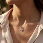 Closeup of a woman wearing the small diamond clover pendant on her neck in a lifestyle scene.